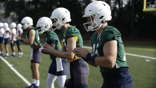 QB lined up at practice working with centers.