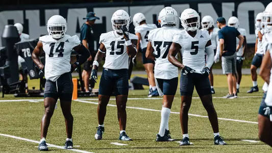 An experienced group of defensive backs eagerly await the next snap in practice.