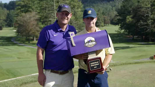 Braedon Wear accepts the J.T. Poston Invite trophy from WCU Coach Tim Eckberg.
