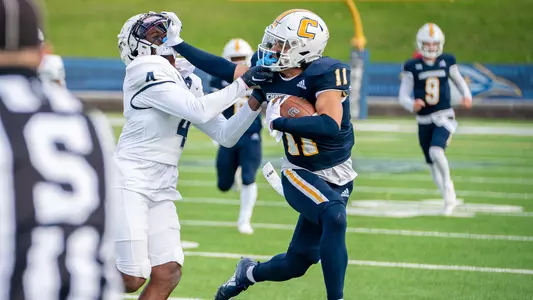 Sam Phillips makes life tough with a stiff arm of a Samford tackler.