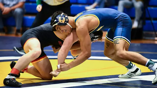 Noah Castillo looks for an opening to spin around for a takedown against VMI.