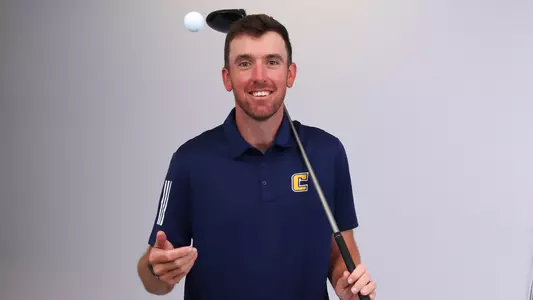 Blaine Woodruff Media Day posed tossing a ball in the air while holding a driver over his shoulder.