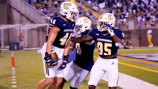 Ty Boeck celebrates his first career TD with Quay Wiggles and John Prince.