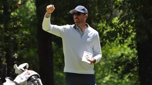 Coach Blaine Woodruff checks the breeze dropping a few grass blades at the SoCon Championships
