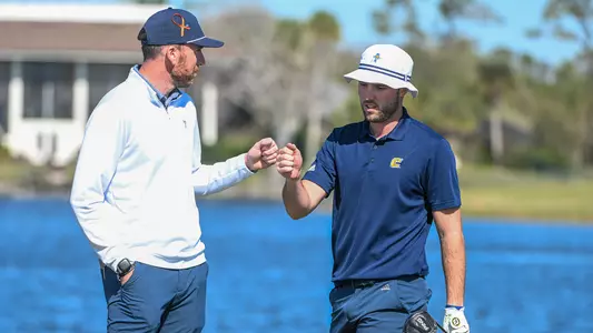 Coach Blaine Woodruff and Samuel Espinosa share a fist bump on the tee