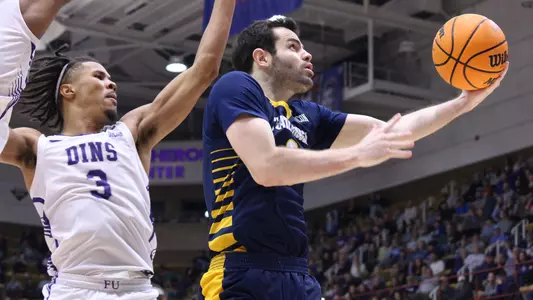 A.J. Caldwell makes a reverse layup driving through the Furman defense