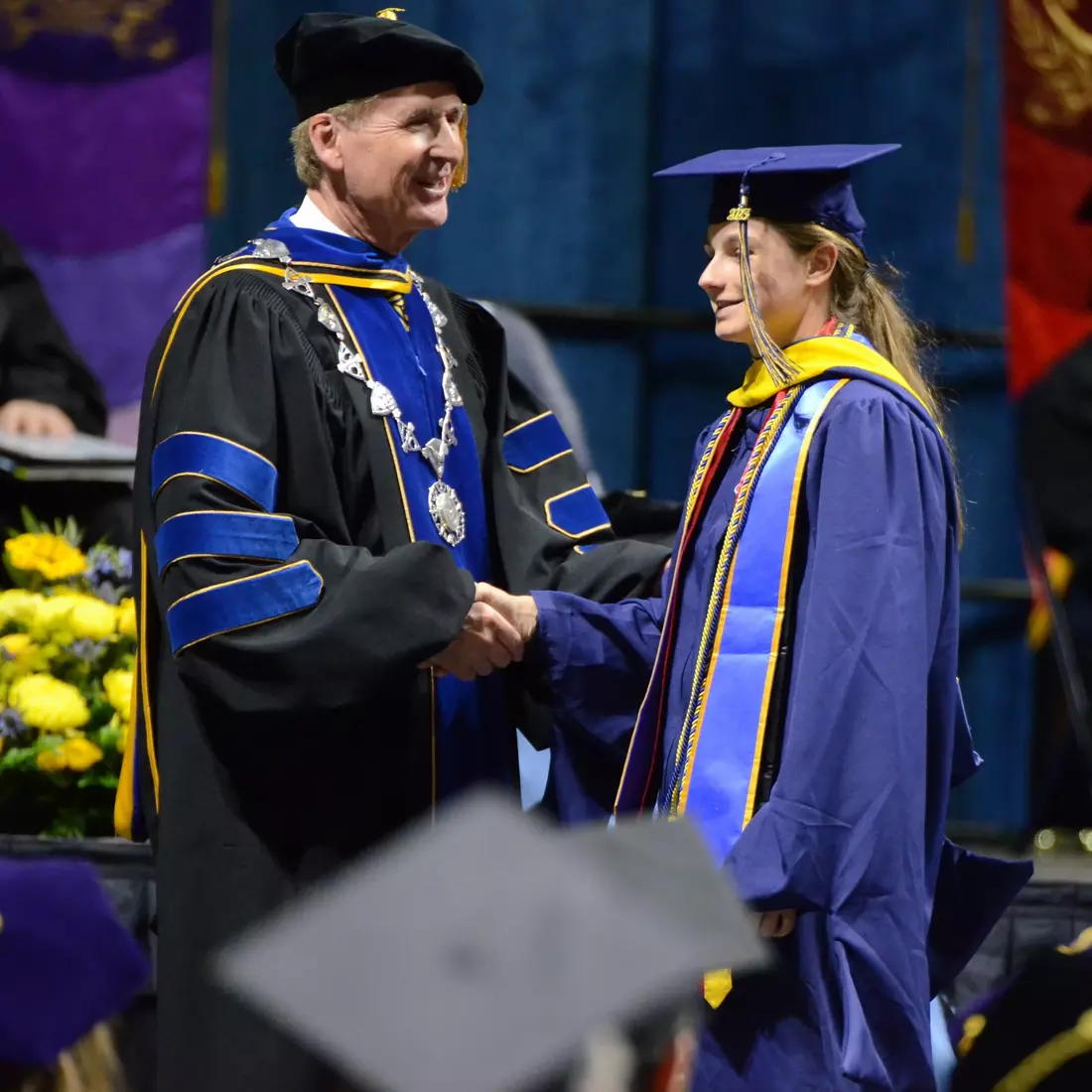 Former women's tennis standout Emma Van Hee is congratulated by UTC Chancellor Dr. Steven Angle on her Master's Degree in Data Analytics.