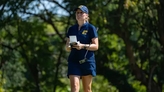 Makenzie Cooper checks her book studying the green at Vandy