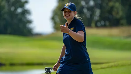 Kera Healey gives our photographer a big smile & thumbs up heading off the green