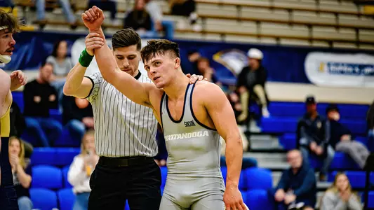 Lincoln Heck gets his hand raised after his first match of 2023-24 against Queens