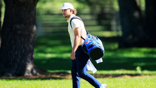 Ethan Whitaker walks towards his ball carrying his bag at the Cullan Brown Collegiate