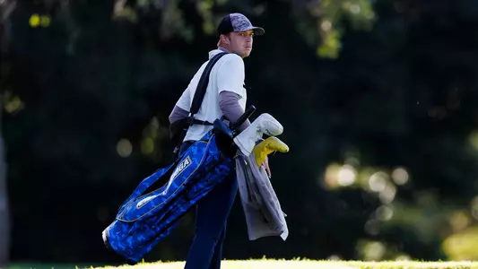 Garrett Engle looks back down the fairway as he carries his bag to the next hole.