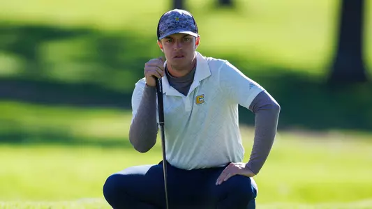 Garrett Engle is crouched surveying the green on day 1 of the 2024 Cullan Brown Collegiate
