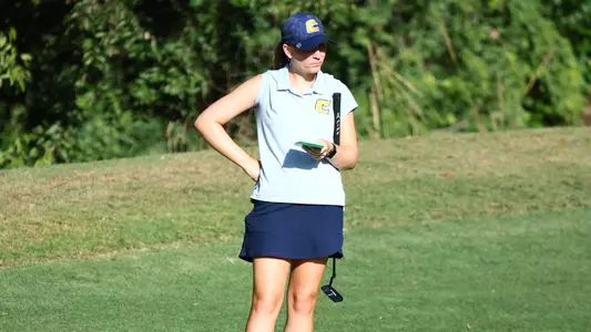 Makenzie Cooper checks her notes and checks out the green at ODU