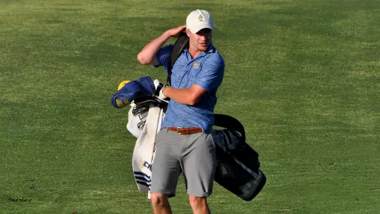 John Houk picks up his bag to head to the green after his approach at the NCAA Championships