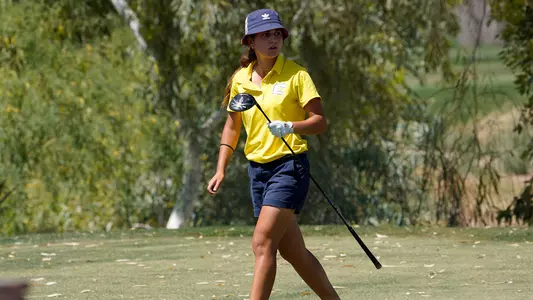Violeta Fernandez-Tagle strides off the tee carrying her driver and looking defiantly down the fairway