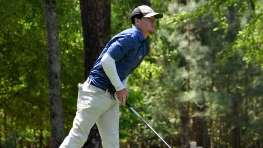 John Houk stares intently at his drive that clears trouble to land safely in the fairway