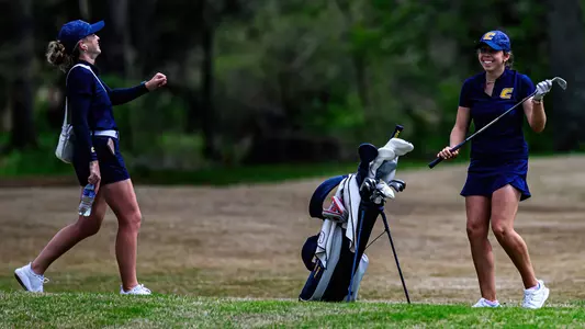 Assistant Coach Sarah Busey and Nieves Martin share a laugh on the course
