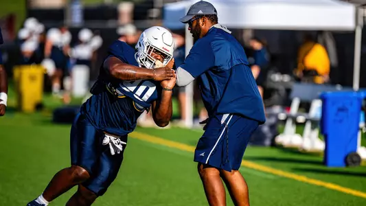 Senior E.J. Thomas works with defensive line coach Julian Miller during 2024 fall camp’s Fan Fest in early August