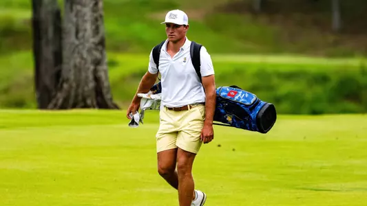 Griffin Law carries his bag down the fairway at the Honors