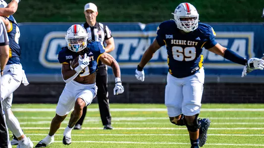 Aidan Donald leads Justus Durant through a gaping hole in the Furman defense