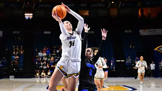women's basketball player shooting the ball on a fast break and getting fouled.
