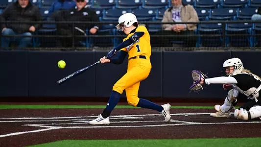 Softball player hitting ball