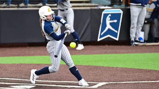 softball player at the plate hitting the ball