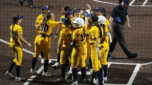 softball player hitting the ball in a game