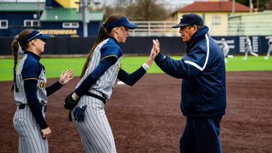 softball coach greeting players before game