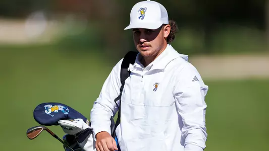 Ethan Whitaker begins to slide his bag off his shoulder arriving at the green