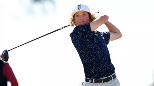 Camden Braidech drives at Briar's Creek with a cloudy white sky in the background