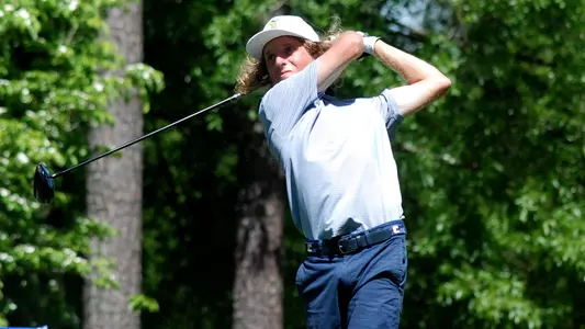 Camden Braidech completes his swing and watches his ball track to the green at the SoCon Championships
