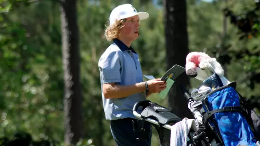 Camden Braidech checks his yardage book at the tee plotting his course on a par 3