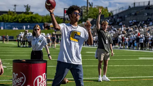 Student competes in the Dr Pepper Scholarship Football Toss during the Wofford game