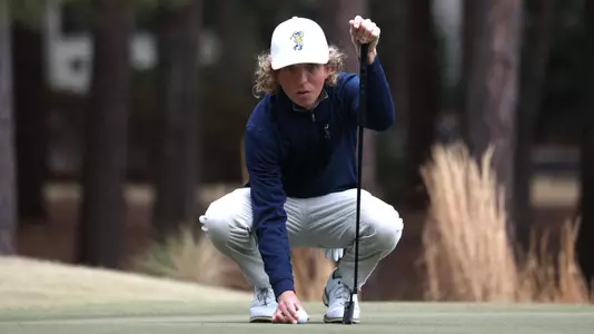 Camden Braidech marks his ball on the green and stares intently at the hole in the Donald Ross Intercollegiate