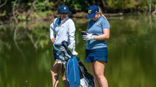 Coach Colette Murray talks on the tee with Kera Healey as theu both smile