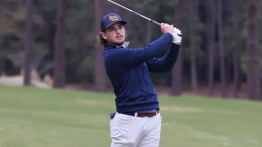 Ethan Whitaker follows his iron shot to the green