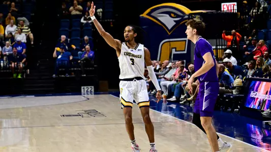 Jikari Johnson holds 3 fingers in the air after hitting a three vs Furman