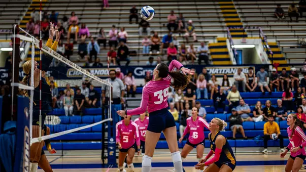 Elena Vukmanov going for a kill against ETSU in UTC's pink jerseys