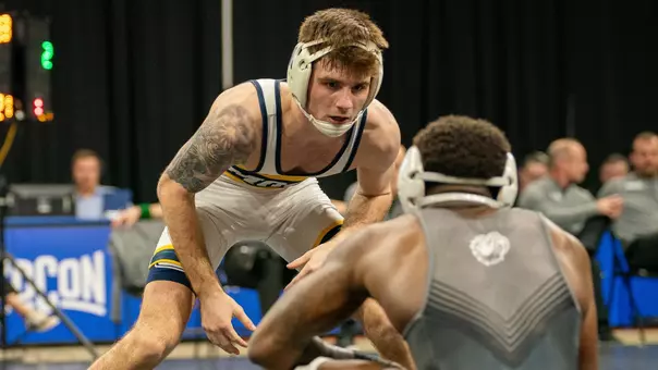 Ethan Uhorchuk looks down at his kneeling opponent looking for an opportunity to attack