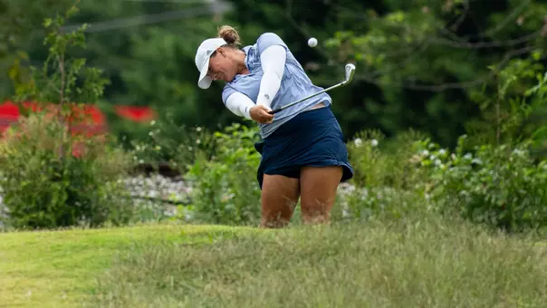 Bella Bugg is mid-swing with her wood pointed down the fairway and the ball still in frame in Knoxville.