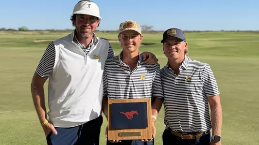 Evan Rogers holds the Trinity Forest Medalist Trophy between Coach Blaine Woodruff and assistant Ryan Hogan