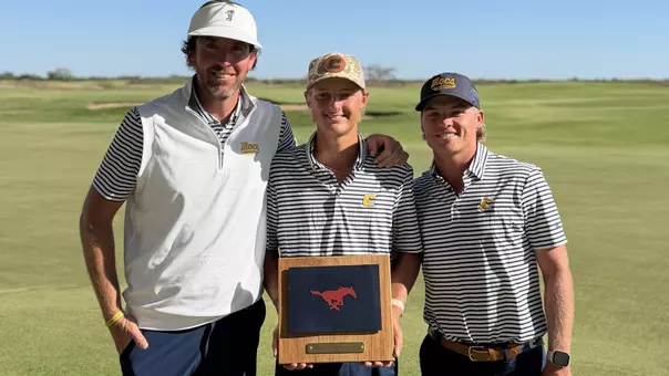 Evan Rogers holds the Trinity Forest Medalist Trophy between Coach Blaine Woodruff and assistant Ryan Hogan