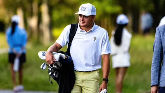 Thad Whitfield strides towards the green carrying his bag over his right shoulder at the Honors