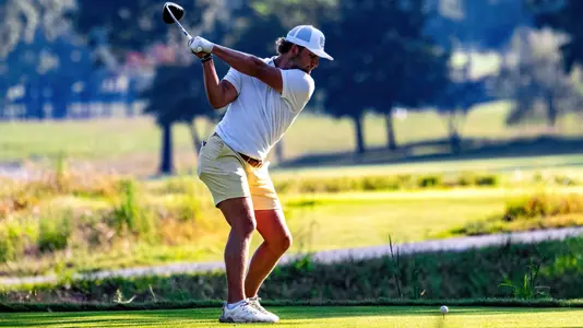 Ward Harris is in the top of his back swing with the photo from behind him on the tee showcasing the lush fairway ahead at the Honors Course