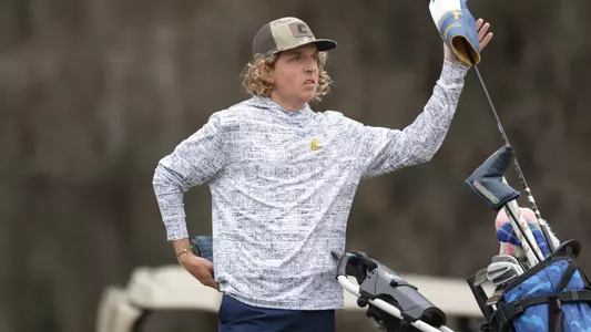 Camden Braidech looks down the fairway as he pulls his driver out of his bag at the tee