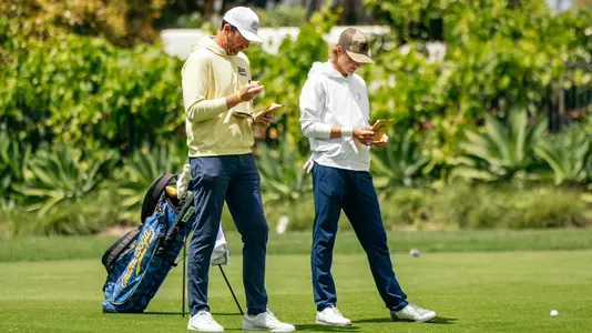 Coach Blaine Woodruff & Evan Rogers check their yardage books from the fairway at Pasatiempo.