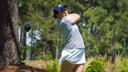 Makenzie Cooper holds her pose as she follows her drive down the fairway.