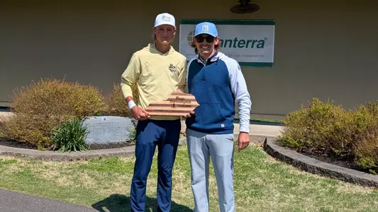 Evan Rogers accepts his winner's trophy from Murray State Coach Jacob Miller